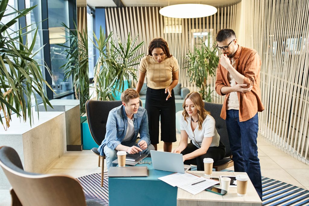 Dans un environnement de bureau, un groupe de collègues discute autour d'une table.